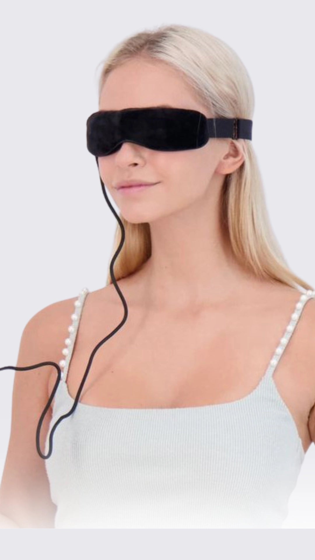 Woman wearing a black eye mask with a white background