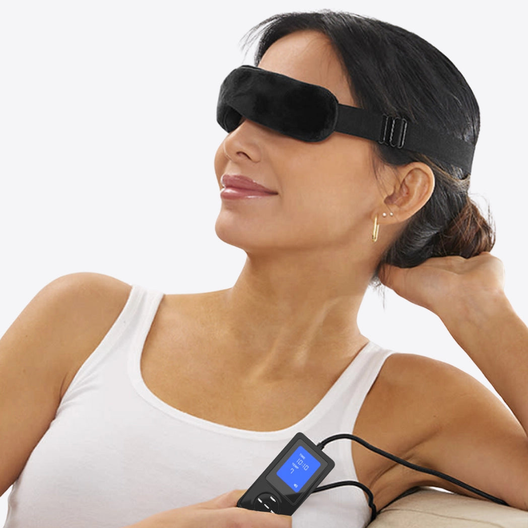 smiling woman wearing wizard research heated eye mask and holding controller